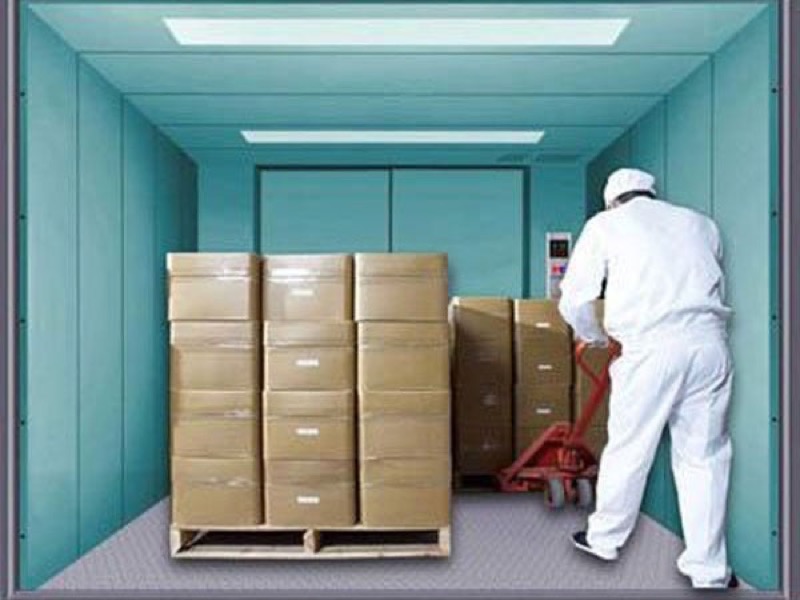 Công nhân đẩy pallet hàng vào cabin thang máy tải hàng